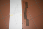 Links die Zeichnung für das Griffstück und rechts die beiden Hölzer dafür. Ich musste ein Stück von der Wenge absägen und werde es an die andere Seite rankleben, da das Stück sonst zu klein gewesen wäre. Ich werde das Wenge-Stück auf das Bubinga-Stück schrauben (an ungenutzten Stellen), damit ich den benötigten Bogen (auf der Zeichnung zu sehen) in einem Rutsch durchsägen kann.