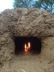 Das erste Feuer !!!!<br />Es ist jetzt 21 Uhr. In ca. fünf Stunden war der Ofen so weit fertig.<br />Grob 50 Liter Wasser sind noch im Bau gespeichert, die auf jeden Fall raus müssen. Daher vorsichtig eingeheizt, um keine zu großen Spannungen zu erzeugen. Das Feuerchen langsam gesteigert.<br />Durch die hohe Feuchtigkeit war es gar nicht einfach, ein gutes Feuer zu erzeugen.<br />Die Anheizphase am Freitag Abend ging ein paar Stunden, bis das Gebrannte Flüssige zu verlockend duftete.